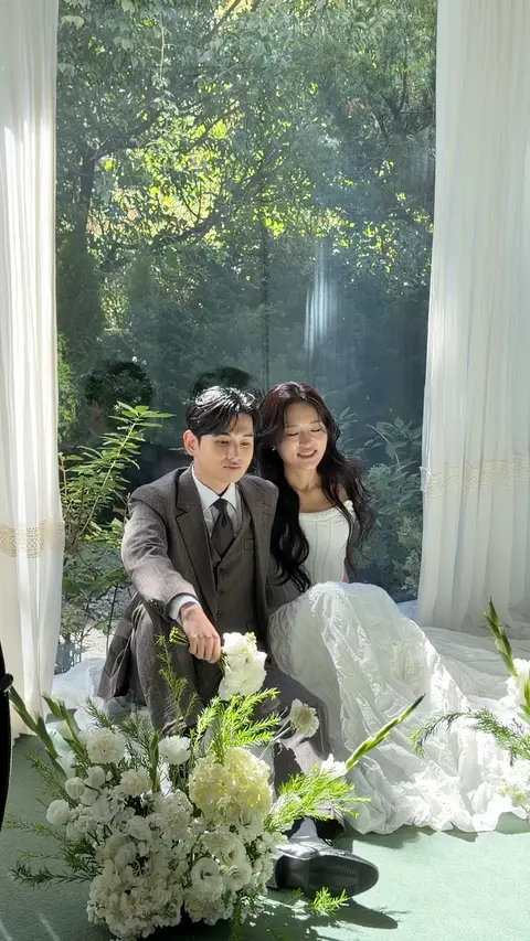 창가에서 흰 꽃 사이에 앉아 웃는 두 사람 (영상)